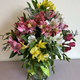 Bouquet of pink, white, and yellow alstroemeria in a glass vase