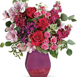 Bouquet of red and pink roses in a glittery purple vase