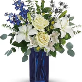 White lilies and roses in a blue glass vase