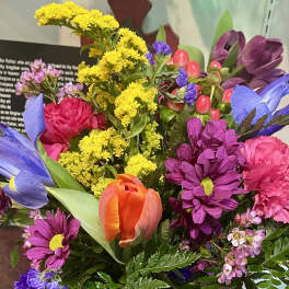 Colorful mixed bouquet with tulips, daisies, carnations, and small filler flowers