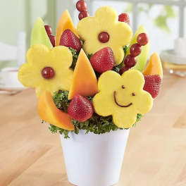 Fruit bouquet in a white cup with carved pineapple flowers and strawberries
