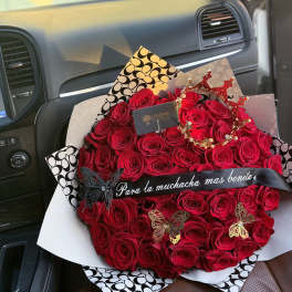 Large bouquet of red roses with butterfly decorations and a ribbon