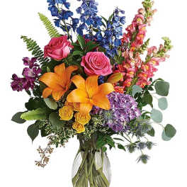 Colorful bouquet with lilies, roses, and snapdragons in a glass vase