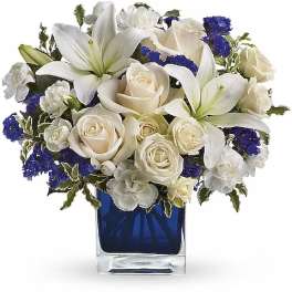 White lilies and cream roses in a blue glass vase