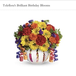 Colorful bouquet in a white vase with curled ribbon decorations