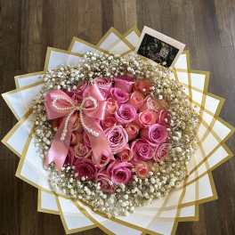 Pink rose bouquet with baby's breath and a satin bow