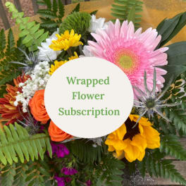 Wrapped bouquet with pink gerbera, orange roses, and yellow flowers