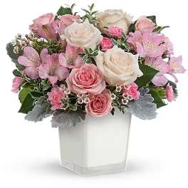 Pink and white rose bouquet in a clear square vase