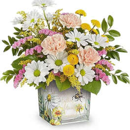 Mixed bouquet of daisies, carnations, and yellow filler flowers in a decorative vase