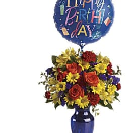 Birthday balloon above a colorful flower arrangement in a blue vase