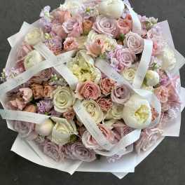 Large pastel bouquet of roses and peonies wrapped in white paper