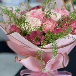Pink and white bouquet wrapped in pink paper with a ribbon