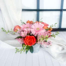 Pink and orange mixed bouquet in a small ribbed vase