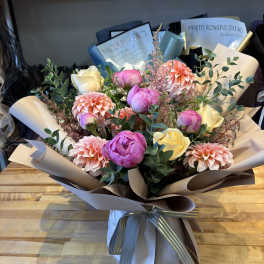 Bouquet of pink and cream flowers wrapped in paper