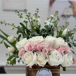 White and blush roses arranged in a wooden box