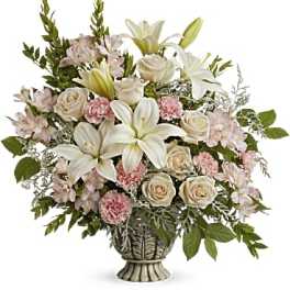 Bouquet of white lilies, cream roses, and pink carnations in a decorative vase