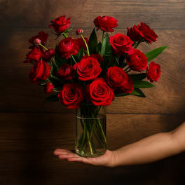 Red roses and ranunculus in a clear glass vase