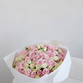 Large bouquet of pink and white roses wrapped in white paper