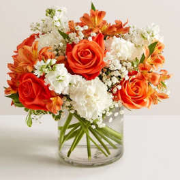 Orange and white bouquet in a clear glass vase