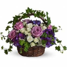 Basket of purple and white roses with ivy accents