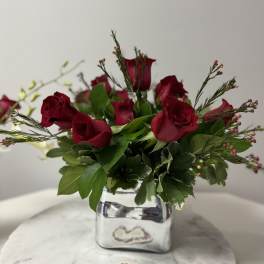 Red rose arrangement in a silver square vase