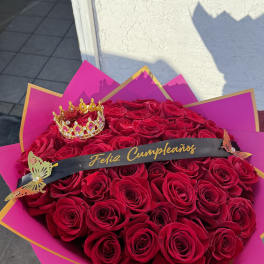Large bouquet of red roses with a small crown and birthday ribbon
