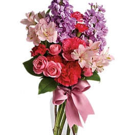 Pink and purple mixed bouquet in a clear glass vase with a ribbon