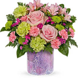 Pink roses and mixed flowers in a purple mosaic vase