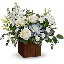 White roses and mixed white flowers in a wooden cube vase
