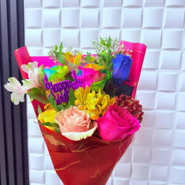 Bright mixed bouquet with roses and alstroemeria in red wrapping
