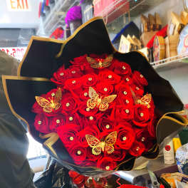 Bouquet of red roses with gold butterfly decorations in black wrap