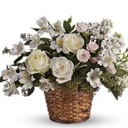 White and pale pink flowers arranged in a woven basket