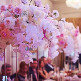 Pink and white floral centerpiece with roses and orchids