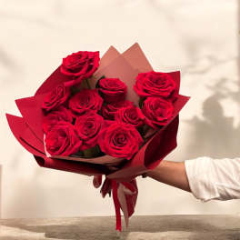 Bouquet of red roses wrapped in burgundy paper