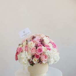 Pink and white rose bouquet in a cream vase
