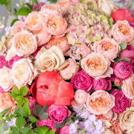 Large bouquet of pink and peach roses with a coral peony