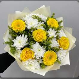 Bouquet of yellow roses and white daisies wrapped in pale paper