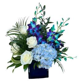 White roses and blue hydrangea in a dark vase with purple-blue orchids