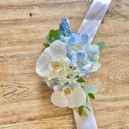 Blue and white floral wrist corsage with ribbon