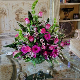 Pink floral arrangement with roses, lilies, and gerbera daisies in a low vase