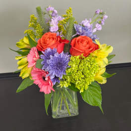 Mixed bouquet in a clear glass vase with roses, daisies, and alstroemeria