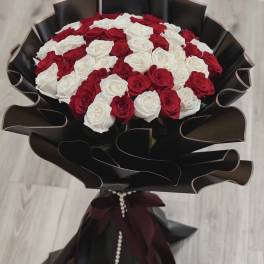 Bouquet of red and white roses wrapped in black paper