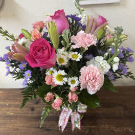 Pink and purple mixed bouquet with roses, lilies, carnations, and daisies