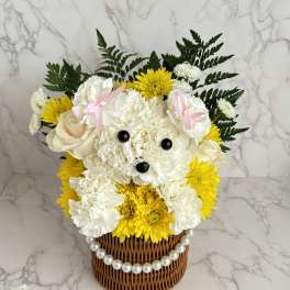 White and yellow flower arrangement in a wicker basket with a pearl trim