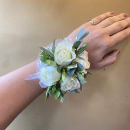 White rose wrist corsage with ribbon and greenery