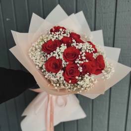 Bouquet of red roses with white baby's breath in pale wrapping