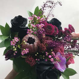 Bouquet of black and pink flowers with green foliage