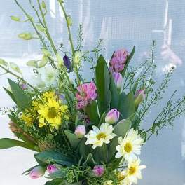 Mixed bouquet with yellow daisies, pink tulips, and white blooms