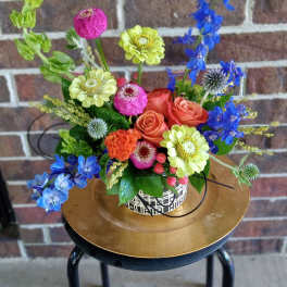 Mixed bouquet in a black vase with pink roses and yellow sunflowers