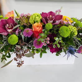 Colorful mixed bouquet with orchids, roses, and green pompon blooms